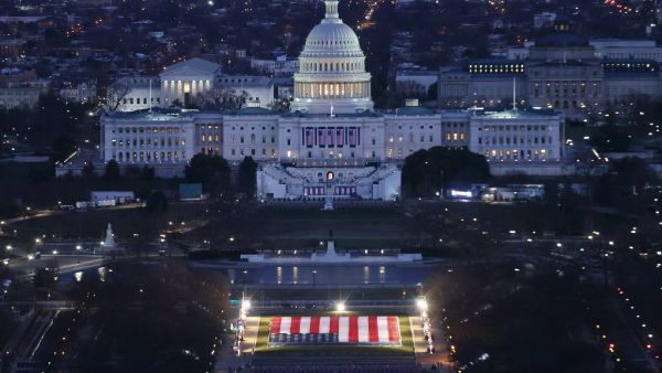 The US Capitol Building is prepared for the inauguration ceremonies for President-elect Joe Biden as the "Field of Flags" are placed on the ground on the National Mall on January 18, 2021 in Washington, DC. Approximately 191,500 US flags will cover part of the National Mall and will represent the American people who are unable to travel to Washington, DC for the inauguration. Joe Raedle / POOL / AFP