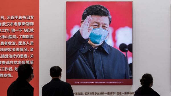 In this picture taken on January 15, 2021, a picture of China's President Xi Jinping with a face mask is displayed as people visit an exhibition about China’s fight against the COVID-19 coronavirus at a convention centre that was previously used as a makeshift hospital for patients in Wuhan. January 23 marks one year since the start of a 76-day lockdown of Wuhan, the central Chinese city where the coronavirus was first detected before sweeping across the world and killing more than two million people.  NICO
