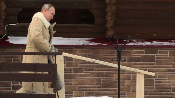 Russian President Vladimir Putin walks to take a dip into the icy waters during the celebration of the Epiphany holiday in Moscow region on January 19, 2021. Mikhail KLIMENTYEV / SPUTNIK / AFP