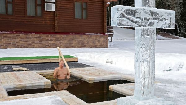 Russian President Vladimir Putin crosses himself as he plunges into the icy waters during the celebration of the Epiphany holiday in Moscow region on January 19, 2021.