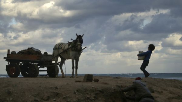 A Palestinian children help their father to collect rubble to sell it in Gaza City on January 20, 2021. Mohammed ABED / AFP