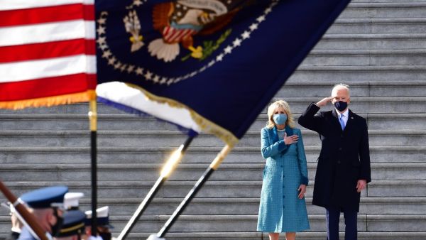 US President Joe Biden salutes as First Lady Jill Biden puts her hand on her heart as they review the readiness of military troops in a pass in review on the east steps of the US Capitol in Washington, DC, on January 20, 2021, after being sworn in at the US Capitol. David Tulis / POOL / AFP