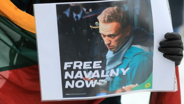 A participant holds a poster with a photo taken by AFP photographer Kirill Kudryavtsev on January 17, 2021, which shows Russian opposition leader Alexei Navalny upon arrival at Moscow's Sheremetyevo airport, during a demonstration in support of Navalny, who is currently jailed, in front of the Russian embassy in Vilnius, on January 23, 2021. Small protests in support of jailed Kremlin critics Alexei Navalny were held in the Baltic states of Lithuania ad Estonia on January 23. Navalny, 44, called on his alli