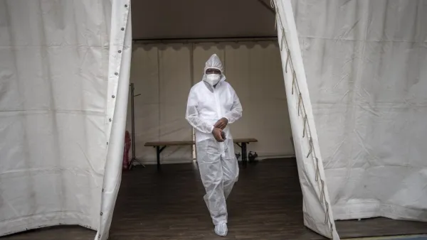 A healthcare worker wearing personal protective equipment (PPE) makes his way out of a temporary ward dedicated to the treatment of possible COVID-19 coronavirus patients at the Nasrec Field Hospital in Soweto, on January 25, 2021. Michele Spatari / AFP