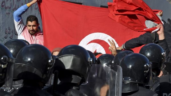 Tunisian police block protesters from accessing the parliament building on January 26, 2021 in Tunis. Tunisian anti-government protesters marched toward the parliament building, which was guarded by riot police as lawmakers inside held a heated debate on a cabinet reshuffle. FETHI BELAID / AFP