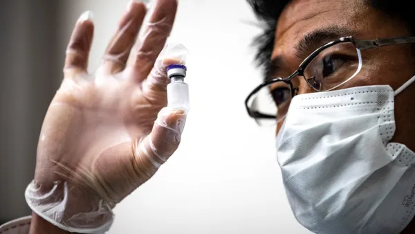 A medical personnel presents a containers with water, which are used to preserve the vaccinnes in a deep freezer during a Covid-19 coronavirus vaccination drill at the Kawasaki City College of Nursing in Kawasaki on January 27, 2021. Philip FONG / AFP