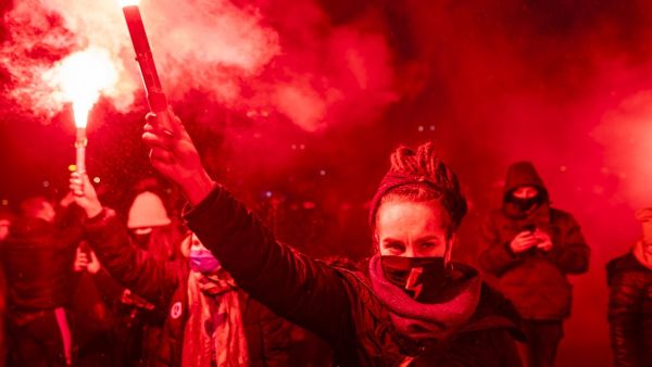 Demonstrators light flares during a pro-choice demonstration in front of the constitutional court in Warsaw, Poland, on January 28, 2021, as part of a nationwide wave of protests since October 22, 2020 against Poland's near-total ban on abortion. Hundreds of Poles rallied in Warsaw against a controversial court verdict imposing a near-total ban on abortion. Protesters also took to the streets elsewhere in the EU member in what was the second night of outrage after the Constitutional Court ruling came into e