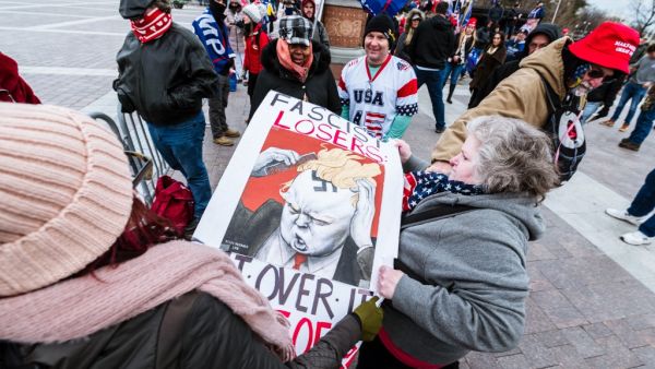 A pair of counter-protesters are confronted by pro-Trump protesters in front of Capitol Building on January 6, 2021 in Washington, DC. A pro-Trump mob stormed the Capitol, breaking windows and clashing with police officers. Trump supporters gathered in the nation's capital today to protest the ratification of President-elect Joe Biden's Electoral College victory over President Trump in the 2020 election. Jon Cherry/Getty Images/AFP