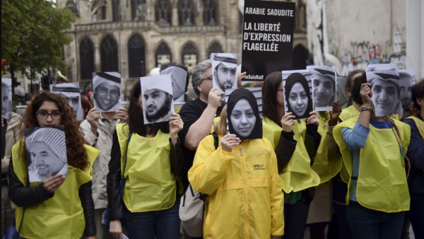 People hold pictures of Samar Badawi (C) and her brother jailed Saudi blogger Raif Badawi (R) as they demonstrate in support of Raif Badawi, who was sentenced to 1,000 lashes for insulting Islam, on May 7, 2015 in Paris. (AFP / Stephane De Sakutin)