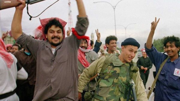 Kuwaiti resistance fighters celebrate with a member of the US Marine Special forces on February 26, 1991, after the Marines entered the small town of Sabahiah, 9 miles from the capital of Kuwait City. (AFP File Photo)