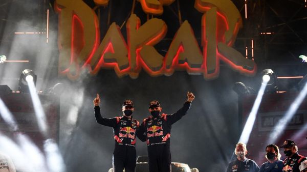 Mini's driver Stephane Peterhansel and his co-driver Edouard Boulanger of France celebrate their victory on the podium after winning the Dakar Rally 2021. (Photo: FRANCK FIFE / AFP)