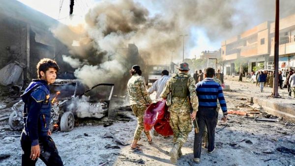 Pro-Turkish Syrian fighters carry away victim of car-bomb explosion last November in Tal Abyad, which has seen several such attacks (AFP)
