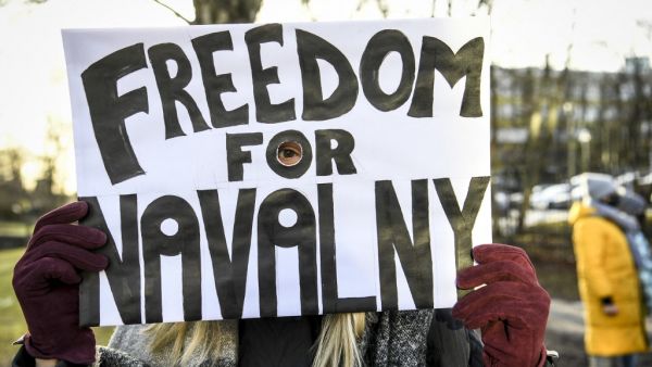 A demonstrator demanding the release of the detained Russian opposition leader Alexei Navalny holds a placard outside the Russian embassy in Stockholm, Sweden, on January 23, 2021. The 44-year-old Chief Kremlin critic Alexei Navalny was arrested at his return in Moscow after spending several months in Germany recovering from a poisoning attack that he said was carried out on the orders of President Vladimir Putin Fredrik SANDBERG / TT News Agency / AFP
