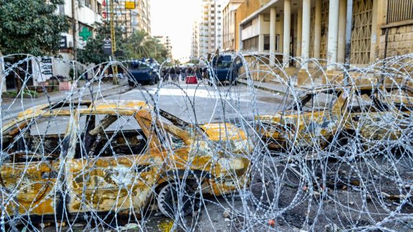 Security forces' vehicles are seen from behind barbed wire in the centre of Lebanon's impoverished northern port city of Tripoli on January 31, 2021. Fathi AL-MASRI / AFP