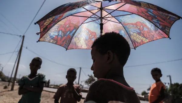 An Eritrean refugee child stands under an umbrella at Mai Aini Refugee camp, in Ethiopia, on January 30, 2021. Eritrean refugees in Ethiopia fear their suffering may not be over, as Prime Minister Abiy Ahmed strains to end a brutal conflict in the northern region of Tigray that has rendered them uniquely vulnerable. Nearly 100,000 refugees from Eritrea, an oppressive, authoritarian nation bordering Ethiopia to the north, were registered in four camps in Tigray when fighting erupted in November between Abiy'