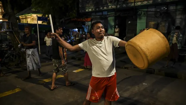 A man hits a plastic container to make noise after calls for protest went out on social media in Yangon on February 3, 2021, as Myanmar's ousted leader Aung San Suu Kyi was formally charged on Wednesday two days after she was detained in a military coup. STR / AFP