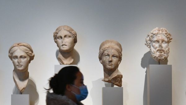A visitor wearing a facemask walks past stone sculptures at The Metropolitan Museum of Art, 'The Met' in New York City on February 9, 2021. Angela Weiss / AFP
