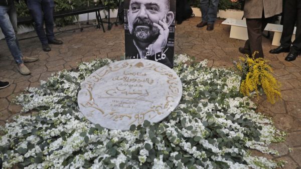 A memorial plaque is placed upon a flower arrangement as friends and family members of slain prominent Lebanese activist and intellectual Lokman Slim (image), attend a memorial ceremony in the garden of the family residence in the capital Beirut's southern suburbs, a week after he was found dead in his car, on February 11, 2021. Slim, found shot dead in southern Lebanon last week at age 58, was an outspoken critic of the Shiite movement Hezbollah and an advocate for preserving the memory of his country's ci