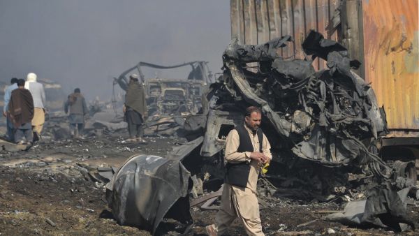 Afghan men walks past the wreckage of gas tankers after a fire accident at Islam Qala on the outskirts of Herat, in the border between Afghanistan and Iran on February 14, 2021. HOSHANG HASHIMI / AFP