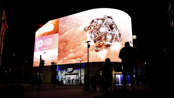 An image showing the simulation of the landing of NASA's Perseverance rover on the planet Mars, where it will look for signs of past microbial life, cache rock and soil samples, and prepare for future human exploration, is livestreamed on the Piccadilly Lights screen in central London, on February 18, 2021. Tolga Akmen / AFP