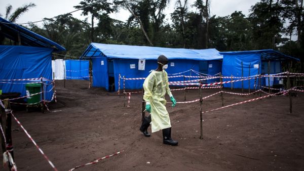In this file photograph taken on June 13, 2017, a health worker walks at an Ebola quarantine unit in Muma, eastern Democratic Republic of Congo Four people have died from the hemorrhagic Ebola virus during a new outbreak in the Democratic Republic of Congo, officials said February 21, 2021. JOHN WESSELS / AFP