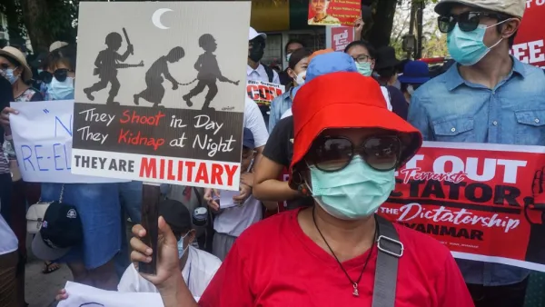 Protesters hold signs as they take part in a demonstration against the military coup in front of the Indonesian embassy in Yangon on February 23, 2021. Sai Aung Main / AFP