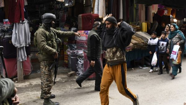 A paramilitary trooper gestures to a pedestrian during a random search in Srinagar on February 26, 2021. Tauseef MUSTAFA / AFP
