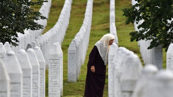 A Bosnian Muslim woman kisses the tombstones of her sons who were killed in the massive killing of Srebrenica during Bosnia's 1992-95 war.