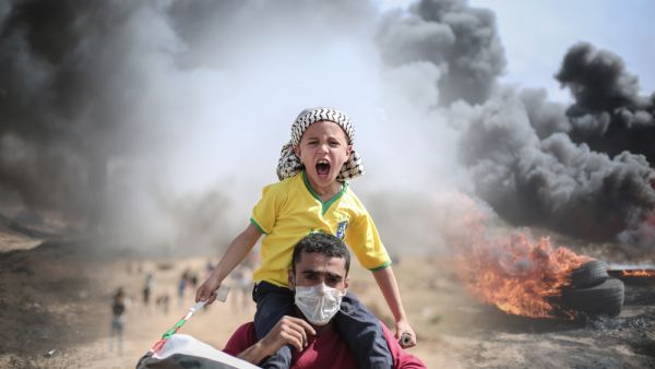 Palestinian father and son protesting at the borders between Gaza strip and Israel  (Shutterstock)	