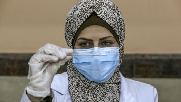 A Palestinian nurse checks the vaccine 