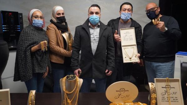 أحمد أبو سنينة يتوسط موظفيه وأكوام من الذهب