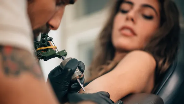 What is the Tattoo artist doing?