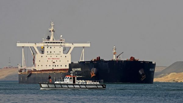 Egyptian coast guards patrol as a ship navigates the Suez Canal 