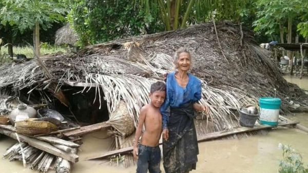 An elderly villager and her grandson in floodwaters