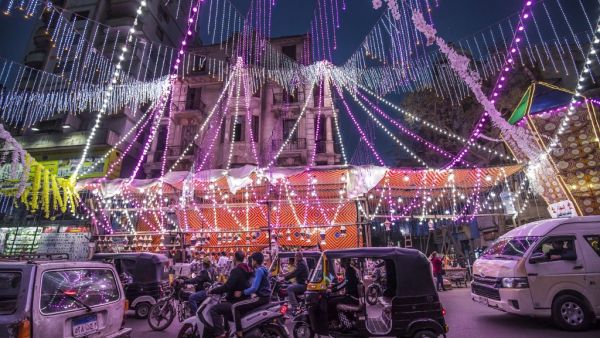 Vehicles, motorcycles, and tuk-tuks (motorised rickshaws) drive past a stall selling Ramadan lanterns along a main street in the in the northern suburb of Shubra (home to a large Christian population) of Egypt's capital Cairo on April 12, 2021, at the start of the Muslim holy fasting month of Ramadan