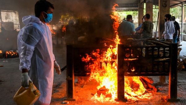 A crematorium staff lights a pyre of a Covid-19 coronavirus victim