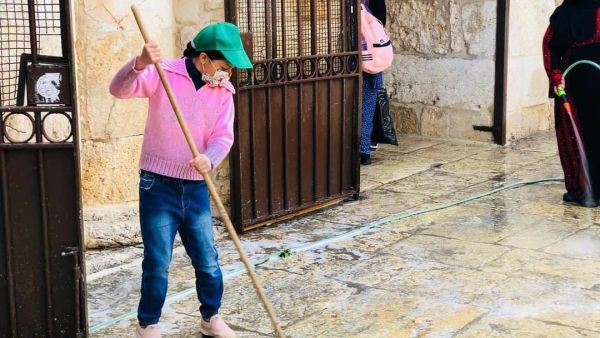 طفلة فلسطينية تنظف باحات المسجد الأقصى