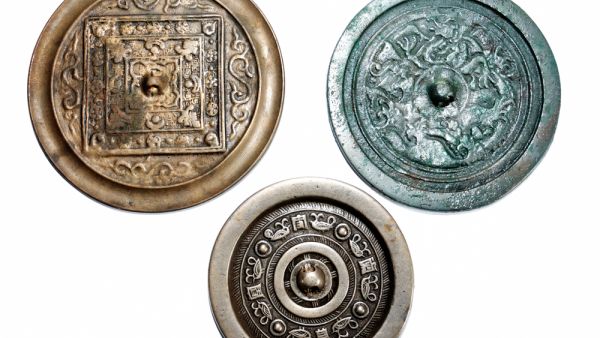 Made of bronze, the mirrors have intricate detail and ancient Chinese text