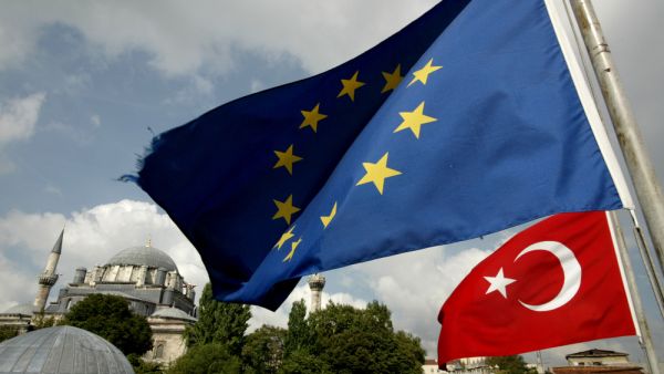 Turkish and EU flags seen in front a mosque in Istanbul