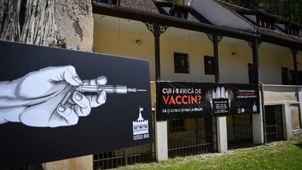 A banner reading in Romanian "Who's afraid of vaccine" and depicting syringes as vampire fangs advertises the vaccination marathon organised at the "Bran Castle" in Bran village on May 8, 2021. Romanian authorities organise during a whole weekend a non-stop vaccination marathon in several locations and Bucharest to offer to the people the opportunity to get vaccinated without prior appointment, hoping to increase the appetite of the population for the vaccines against Covid-19