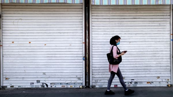An Iranian woman wearing a protective mask due to the COVID-19 pandemic walks past a shuttered shop in Enghelab suqare in the centre of Iran's capital Tehran on May 16, 2021. Iranian newspapers voiced concern about the potential turnout for next month's presidential poll, a day after candidate registration ended with several heavyweights joining the race.