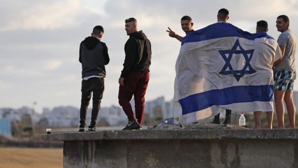 Israelis gather to watch the Iron Dome aerial defence system launch a missile to intercept a rocket launched from the Gaza Strip, above the southern Israeli city of Ashdod