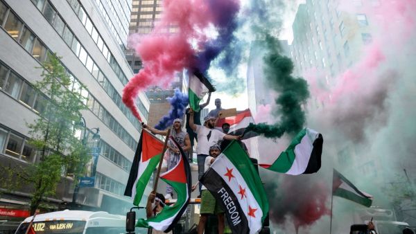 Demonstrators hold Palestine and Syrian flags in support of Palestine in midtown Manhattan, New York City