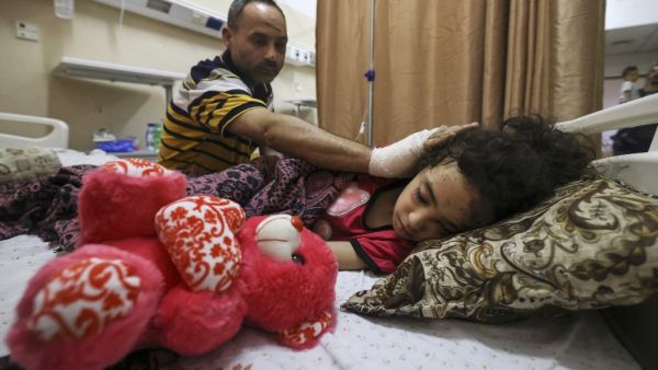 Palestinian Ryad Eshkuntana, checks his daughter Suzy, as they receive medical care at Al-Shifa hospital in Gaza City, on May 19, 2021, after his wife and other children were killed in an Israeli air strike. Deafening air strikes and rocket fire once more shook Gaza overnight and early today amid an international diplomatic push to broker a ceasefire after more than a week of bloodshed