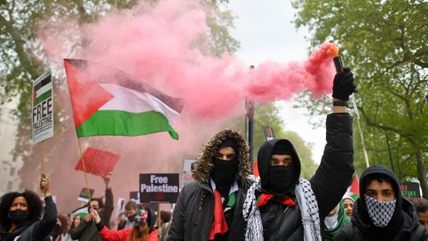 Pro-Palestine protesters set Israeli flags on fire outside the London embassy
