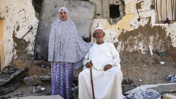 Palestinian Mahmoud Abu Shamala and his wife Raja pose for a photo by their destroyed home in Gaza City on May 27, 2021, in the aftermath of the conflict between Israel and the Gaza-based Hamas movement
