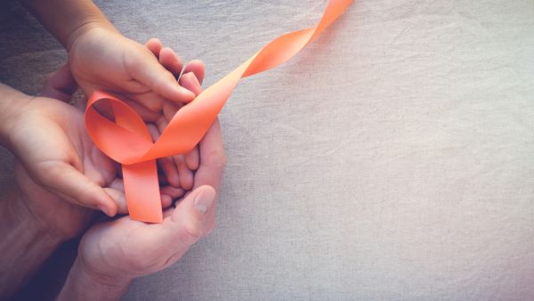 Adult and child hands holding orange Ribbons, Leukemia cancer awareness and Multiple sclerosis awareness