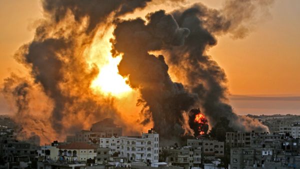 A fire rages at sunrise in Khan Yunish following an Israeli airstrike on targets in the southern Gaza strip, early on May 12, 2021. Israeli air raids in the Gaza Strip have hit the homes of high-ranking members of the Hamas militant group, the military said Wednesday, with the territory's police headquarters also targeted.