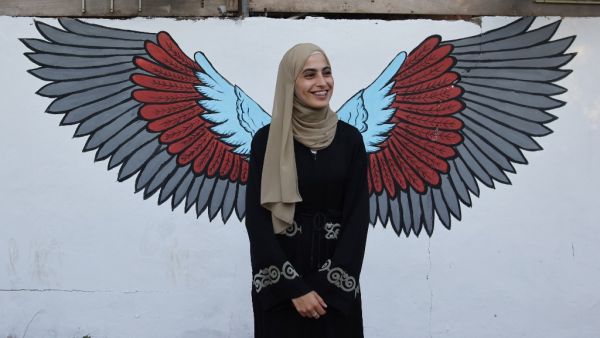 Palestinian activist Mona el-Kurd, 23, talks to well wishers upon arrival at home in the neighbourhood of Sheikh Jarrah in Israeli-annexed east Jerusalem after being released from an Israeli police station
