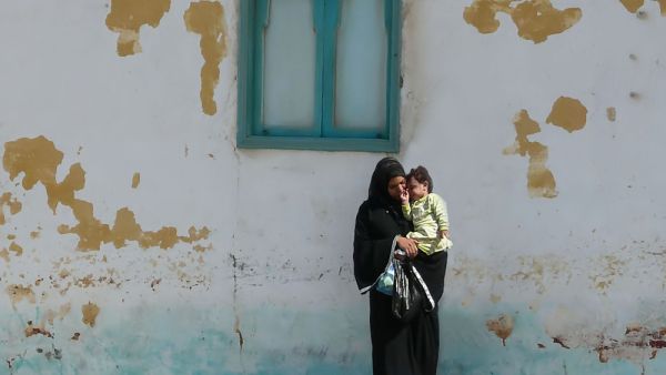 A young mother in a black abaya and hijab 